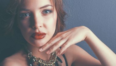 Siyah elbiseli, akşam makyajlı güzel bir kadın.