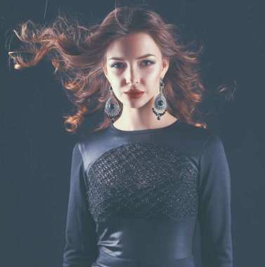 Siyah elbiseli, akşam makyajlı güzel bir kadın.