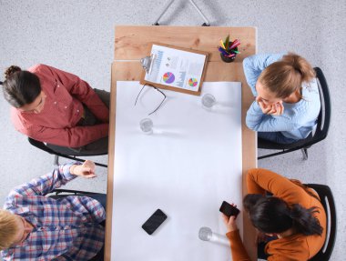 İş adamları iş toplantısında, ofiste oturup tartışıyorlar.