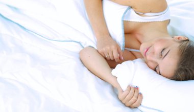 Yatakta rahat ve mutlu bir şekilde yatan güzel bir genç kadın.