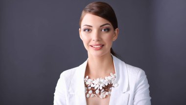 Boncuklar, gri arka plan üzerinde duran genç kadın portresi