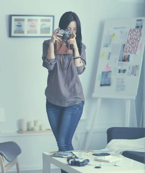 Kvinnlig fotograf sitter på skrivbordet med bärbar dator — Stockfoto