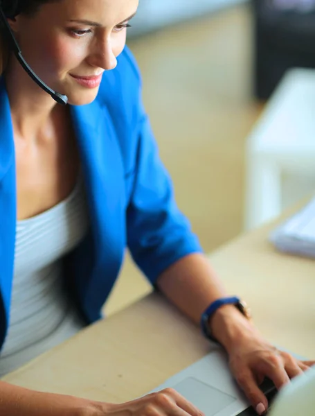 Portrait de belle femme d'affaires travaillant à son bureau avec casque et ordinateur portable. — Photo