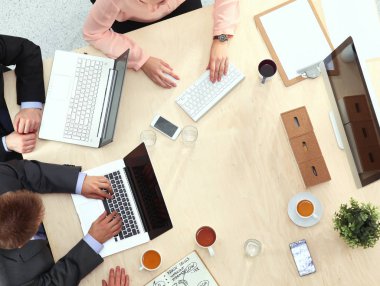 İş adamları toplantıda, ofiste oturup tartışıyorlar.