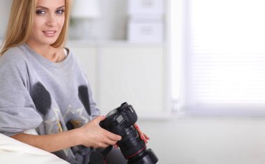 nő ül a kanapén házában a kamera