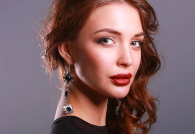 Siyah elbiseli, akşam makyajlı güzel bir kadın.