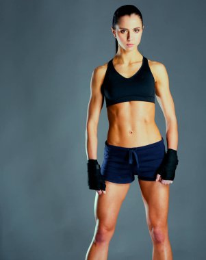 Spor giyim siyah arka plan karşı poz kas genç kadın