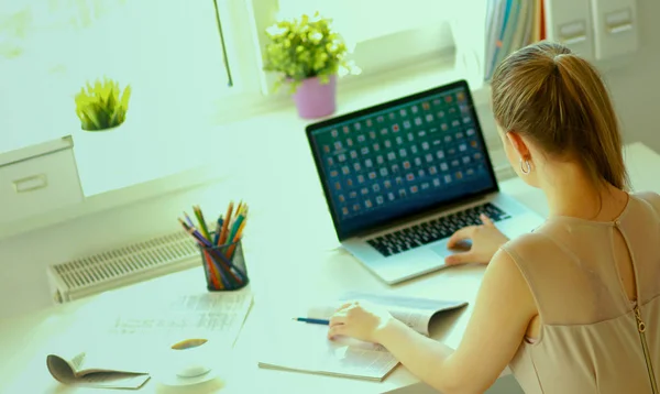 Kvinna med dokument sittande på skrivbordet och laptop — Stockfoto