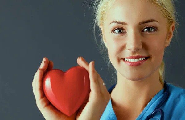Jonge arts vrouw met de stethoscoop houden hart — Stockfoto