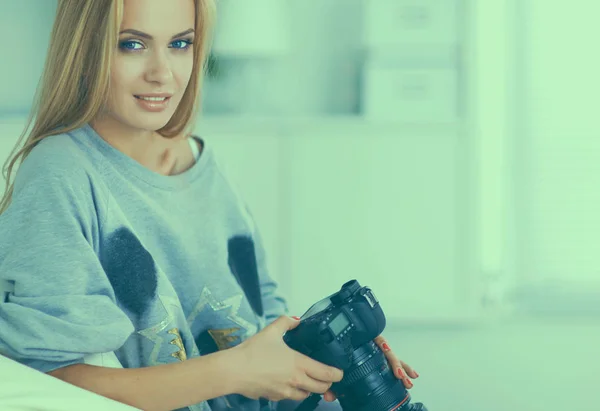 Donna seduta su un divano nella sua casa con macchina fotografica — Foto Stock