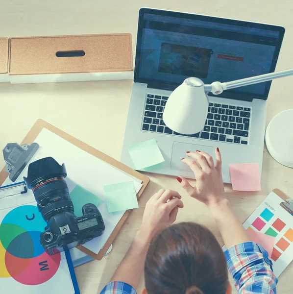 Vrouwelijke fotograaf zittend op het bureau met laptop — Stockfoto