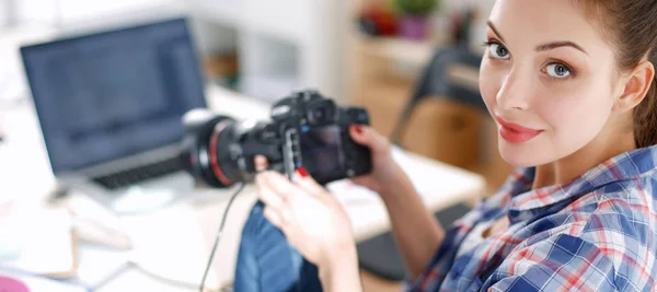 Vrouwelijke fotograaf zittend op het bureau met laptop — Stockfoto