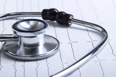 Masada yatan elektrokardiyogramda stetoskop.
