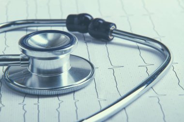 Masada yatan elektrokardiyogramda stetoskop.