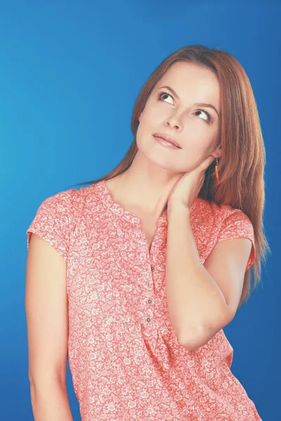 Schöne, lässige junge Frau steht isoliert vor blauem Hintergrund — Stockfoto