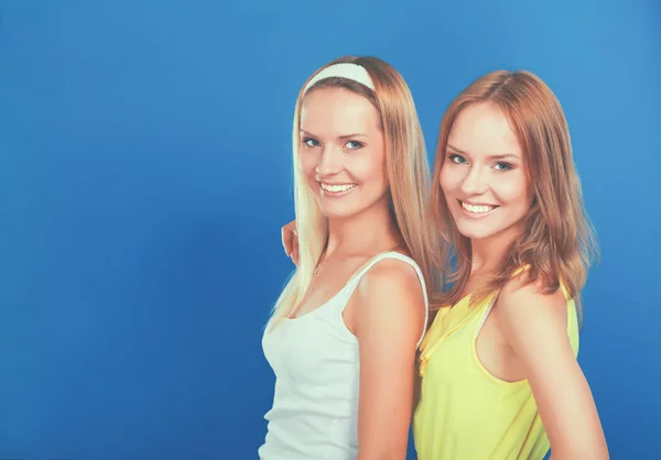 파란색 배경에 고립 웃는 두 여자의 근접 촬영 초상화 — 스톡 사진