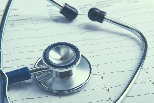 Stethoscoop op elektrocardiogram liggend aan het bureau — Stockfoto