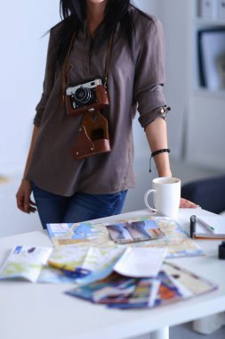 Masada dizüstü bilgisayarla oturan kadın fotoğrafçı.