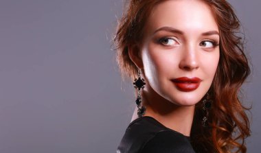 Siyah elbiseli, akşam makyajlı güzel bir kadın.