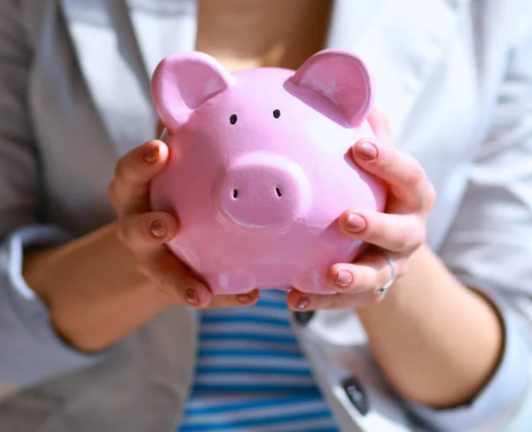 Young beautiful woman standing with piggy bank money box, on building — Stock Photo, Image
