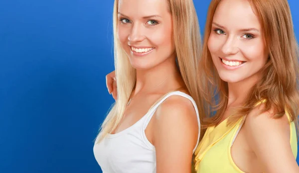 Retrato de cerca de dos mujeres sonriendo aisladas sobre fondo azul —  Fotos de Stock