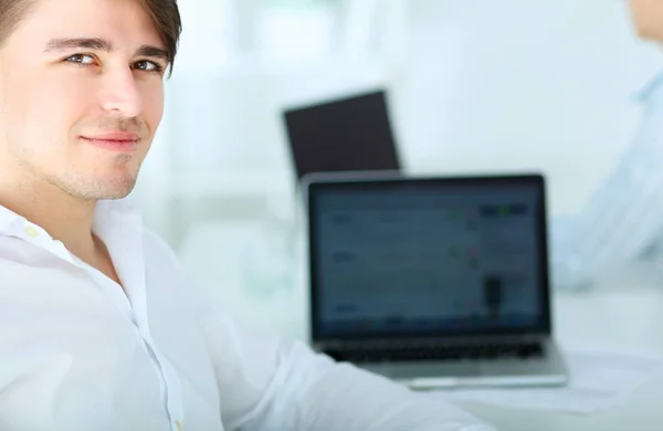 Young businessman working in office, sitting at desk — Stock Photo, Image