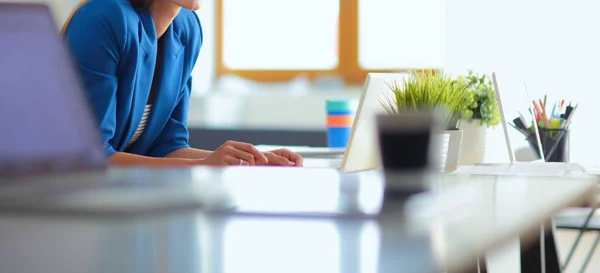 Woman sitting on the desk with laptop — Stock Photo, Image
