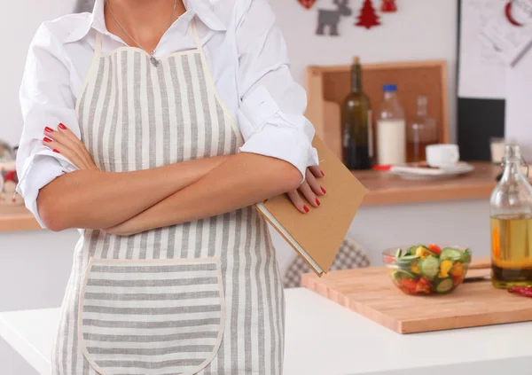Usmívající se mladá žena stojící v kuchyni — Stock fotografie