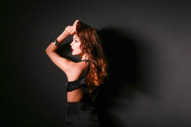 Siyah elbiseli, akşam makyajlı güzel bir kadın.