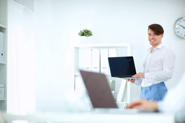 Young businessman working in office, sitting at desk — Stock Photo, Image