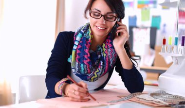 Terzi kadın kağıt üzerinde kıyafet deseni tasarlıyor.