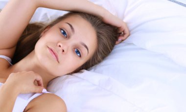 Yatakta rahat ve mutlu bir şekilde yatan güzel bir genç kadın.