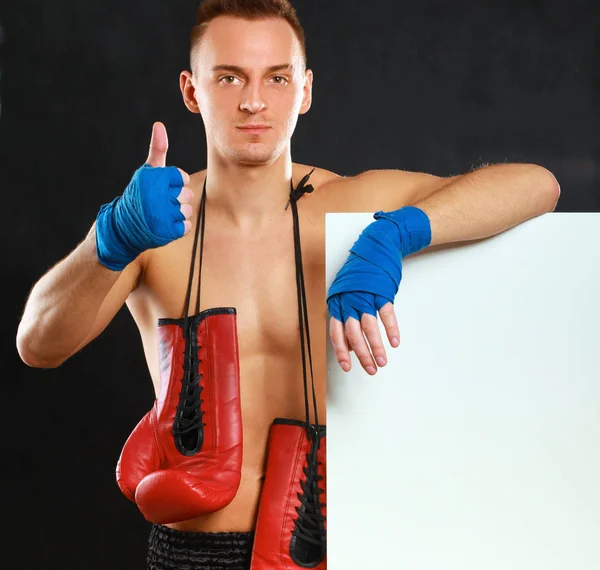 Young handsome boxer man standing near board and showing ok, isolated on black background — Stock Photo, Image