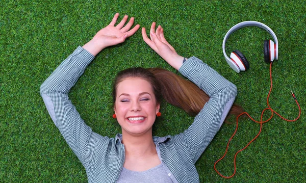 Relaxed woman  lying on the grass near headset — Stock Photo, Image