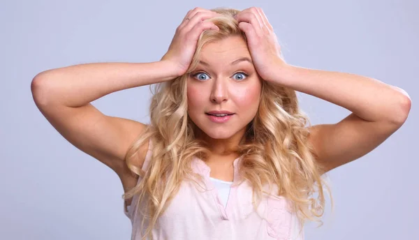 Junge emotionale Frau, die auf grauem Hintergrund steht — Stockfoto