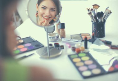 Genç güzel kadın ayna, Masa başında oturan yakınındaki makyaj yapma