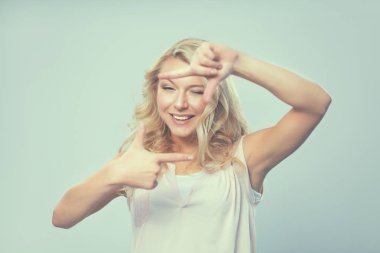 Genç kadın parmakları ile bir çerçeve oluşturma