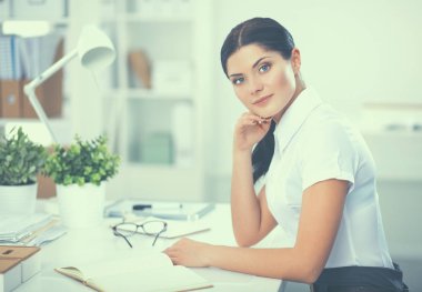 Ofiste masa başında oturan çekici bir iş kadını.
