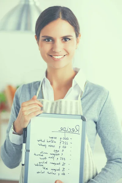 Frau zu Hause in der Küche, neben Schreibtisch mit Ordner — Stockfoto