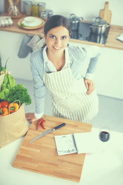 Vrouw maken van gezonde voeding staande glimlachend in keuken — Stockfoto