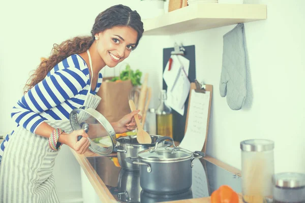 制作健康食品站在厨房里微笑的女人 — 图库照片