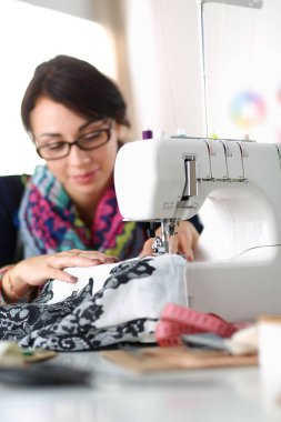 Çalışırken dikiş diken genç bir kadın.