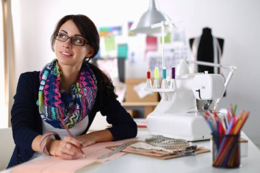 Terzi kadın kağıt üzerinde kıyafet deseni tasarlıyor.