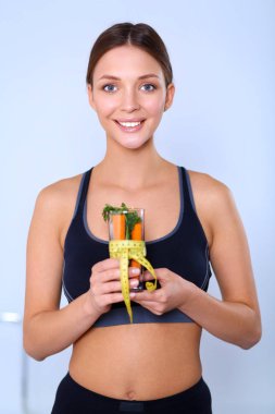 Bir içme tutan kadın taze meyve salatası gözlük çevresinde şerit metre ile dolu cam