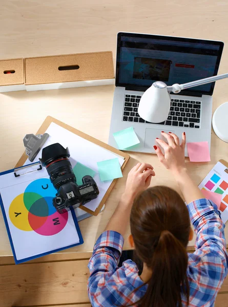 Vrouwelijke fotograaf zittend op het bureau met laptop — Stockfoto