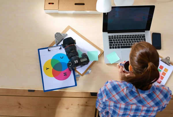 Female photographer sitting on the desk with laptop — Stock Photo, Image