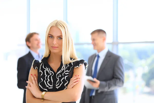 Zakenvrouw permanent op voorgrond in office — Stockfoto