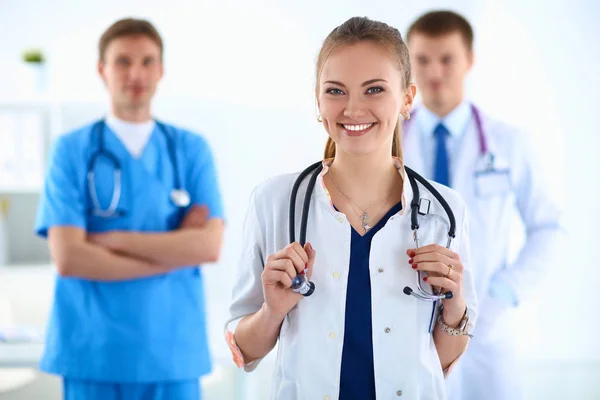 Médica atraente na frente do grupo médico — Fotografia de Stock