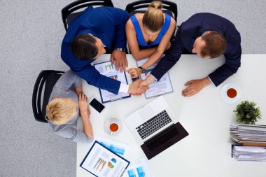 İş adamları toplantıda, ofiste oturup tartışıyorlar.