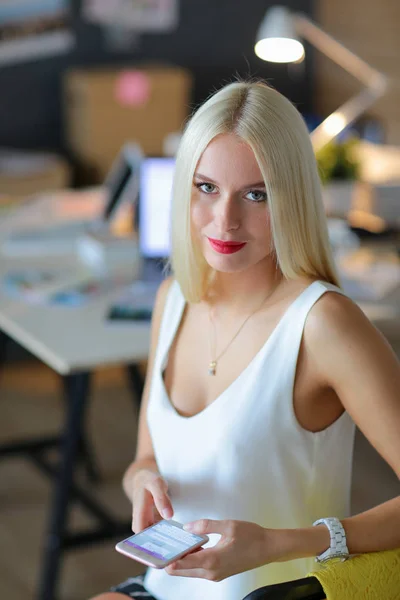 Mujer diseñador usando en el teléfono móvil en la oficina — Foto de Stock